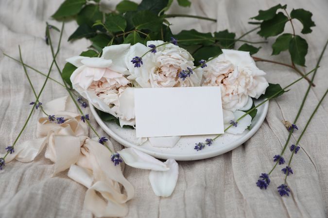 Festive floral composition with English roses, lavender, ribbon with blank business card, wedding invitation mockup