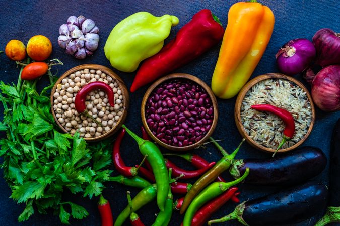 Fresh vegetables, legumes and rice on stone background with copy space