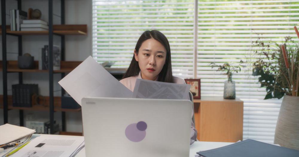 Young and Stylish South Korean Female Professional Immersed in Laptop Computer Work at Her Cozy Home Office