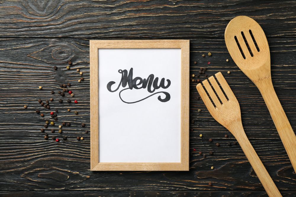 Frame with text Menu and cutlery on wooden background