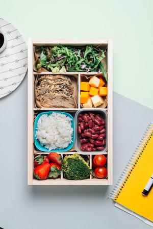 Food box with diet ingredients by copybook and plate