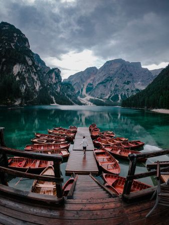 Man standing on a dock on a lake in Tirol, Trentino-South Tyrol, Italy