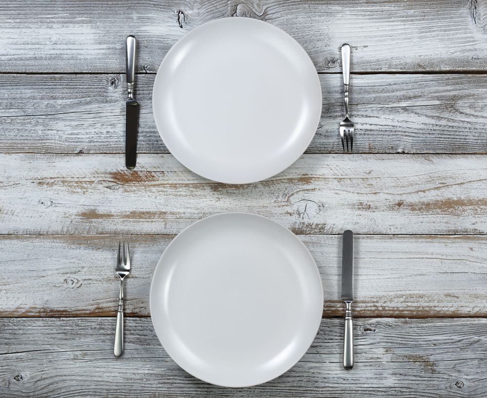 Dinner table setting on rustic wood in overhead view