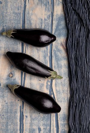 Ripe eggplants on shabby tabletop