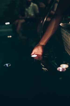 Woman swimming in pool with candles