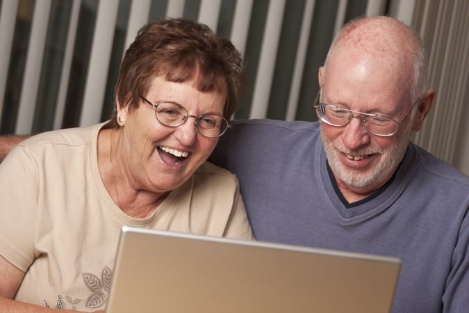 Smiling Mature Adult Couple Having Fun on the Computer