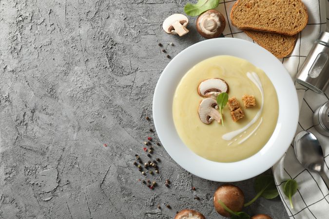 Looking down at bowl of mushroom soup on marble table with copy space