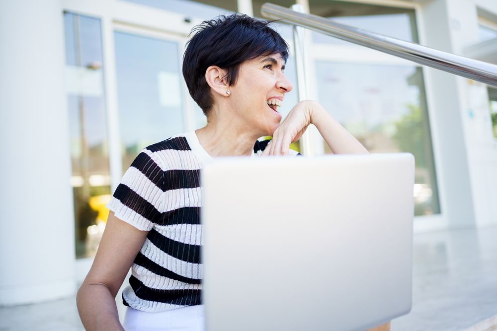Women laughing behind computer