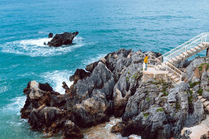 Woman looking at waving sea from steps