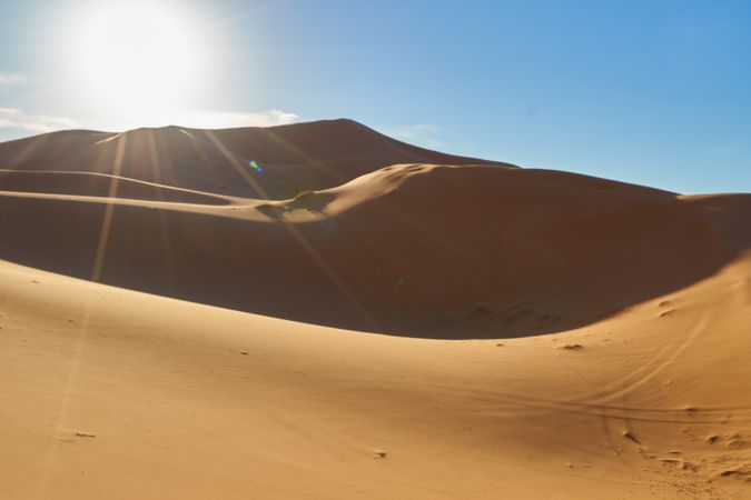 Sand dunes and blue sky with sun