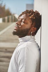 Thoughtful Black man near wall