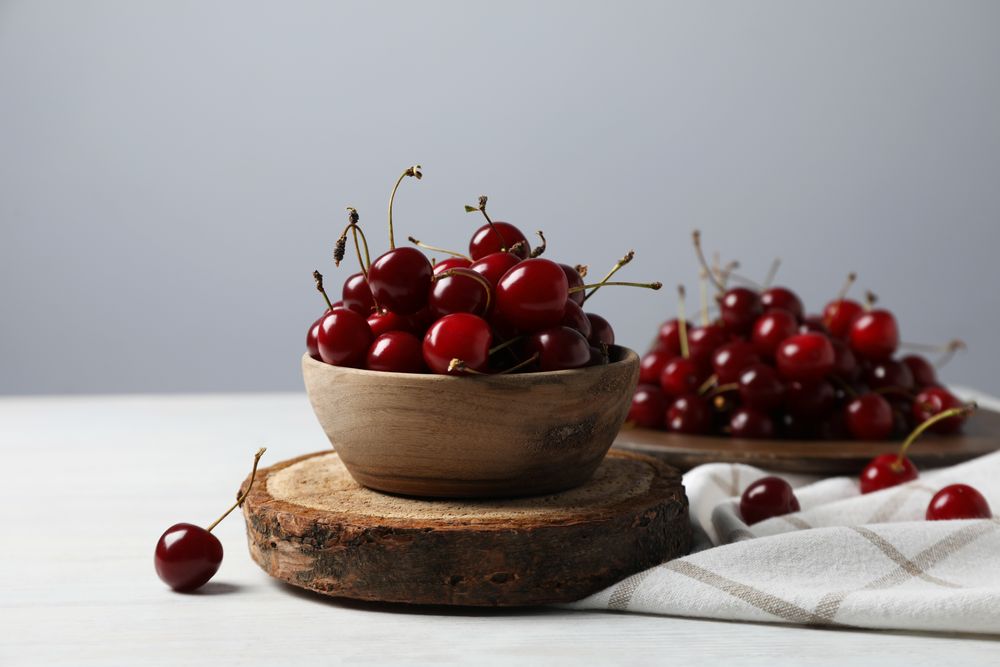 Ripe juicy fruits in a bowl on a wooden stand