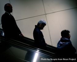 Side view of three men on escalator 56E8L0