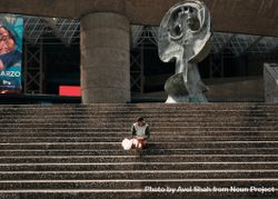 Man sitting alone on staircase outside large center bxOld4