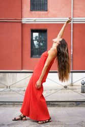 An Elegant Woman in a Beautiful Red Dress Posing Gracefully Outdoors in a Scenic Setting