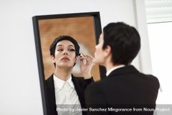 Woman wearing suit with blazer jacket doing her make up 42YDe5