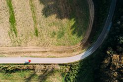 Van riding on countryside road near field