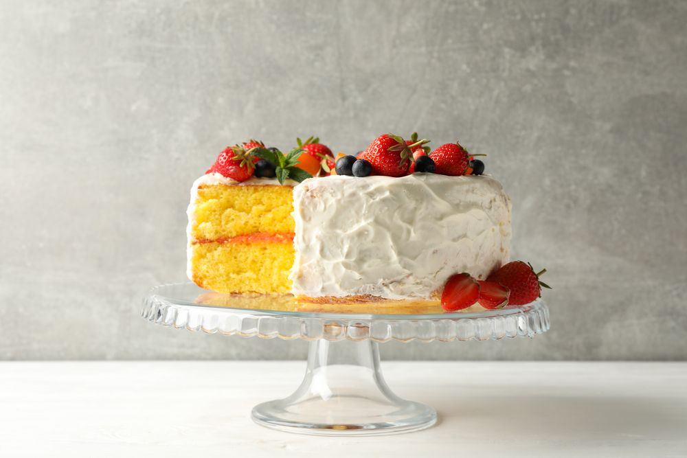 Composition with delicious berry cream cake against gray background. Tasty dessert
