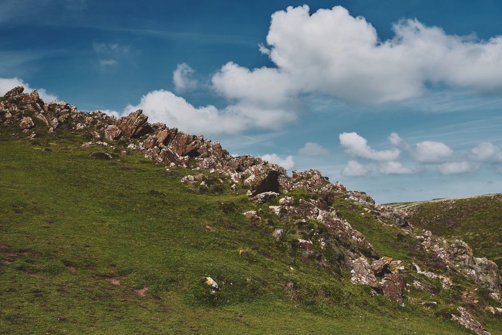 Rocky hill under a cloudy blue sky