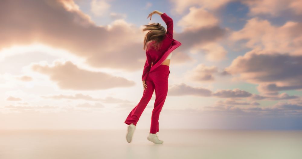 Athletic Woman in Stylish Outfit Dancing Energetically in Studio with Sky Background. Creative Female Performing Contemporary Dance Choreography On Set During Virtual Production