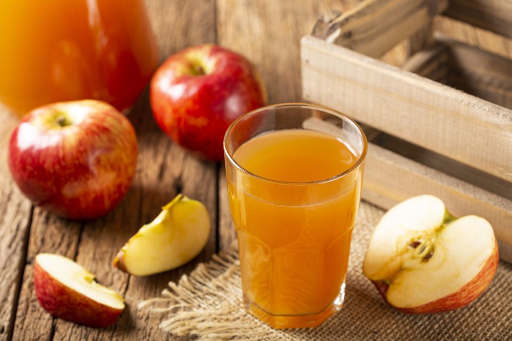 Apple juice and red apples on the table.