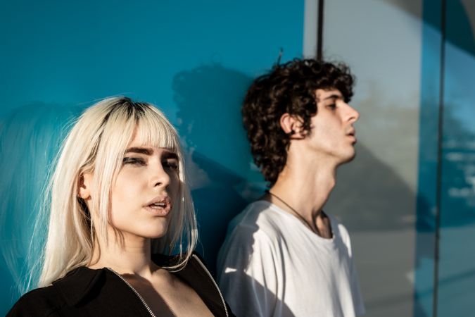 Charming sensual lady and calm guy against blue glossy wall