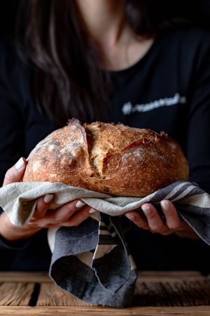 Crop person holding some bread