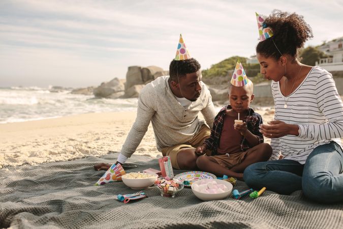 Boy celebrating his birthday with parents at beach
