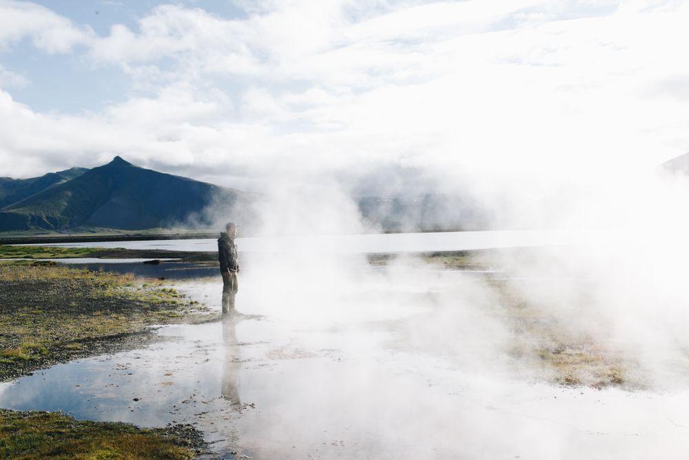 Man at geyser on overcast day