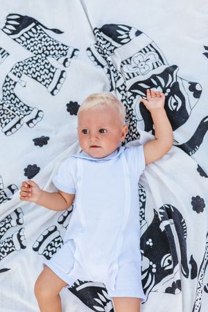Top view of a blond baby lying on a blanket