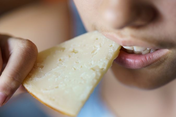 Girl biting into slice of cheese
