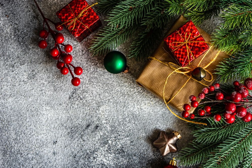 Christmas frame with branch and gifts on stone background