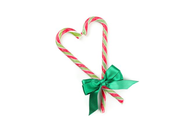 Sweet candy canes with bow isolated on plain background