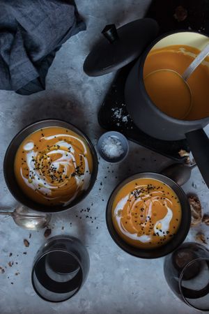 Bowls with pumpkin cream soup on table