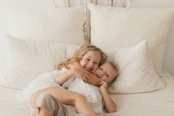 Sister embracing little brother at home