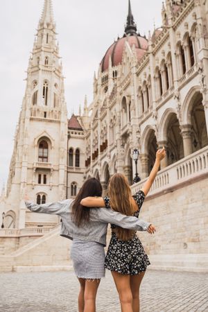 Funny girl friends on old square with dome buildings
