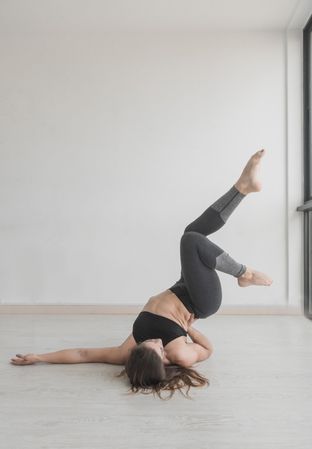Flexible female training upside down in studio