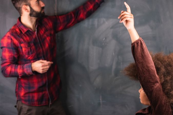Multiracial teacher and pupil in classroom at math lesson