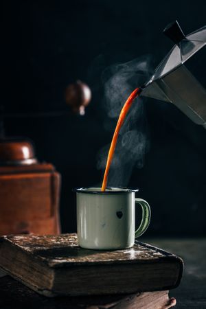 Pouring hot coffee in an enamel cup