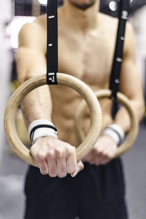 Man training with gymnastic rings in gym