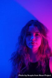 Portrait of adolescent girl in purple lit studio 5QXEG0