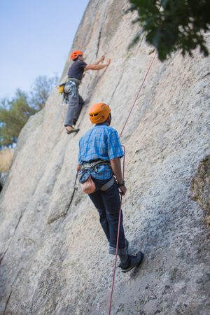 Climbers in safety harness climbing mountain