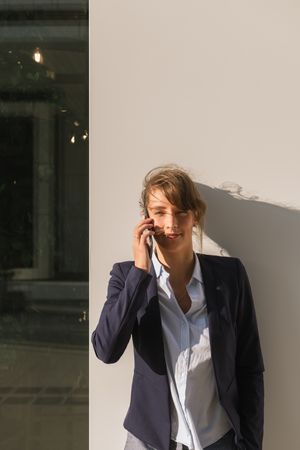 Cheerful female manager speaking on smartphone on street