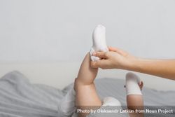 Woman putting socks on baby 5nY7l0