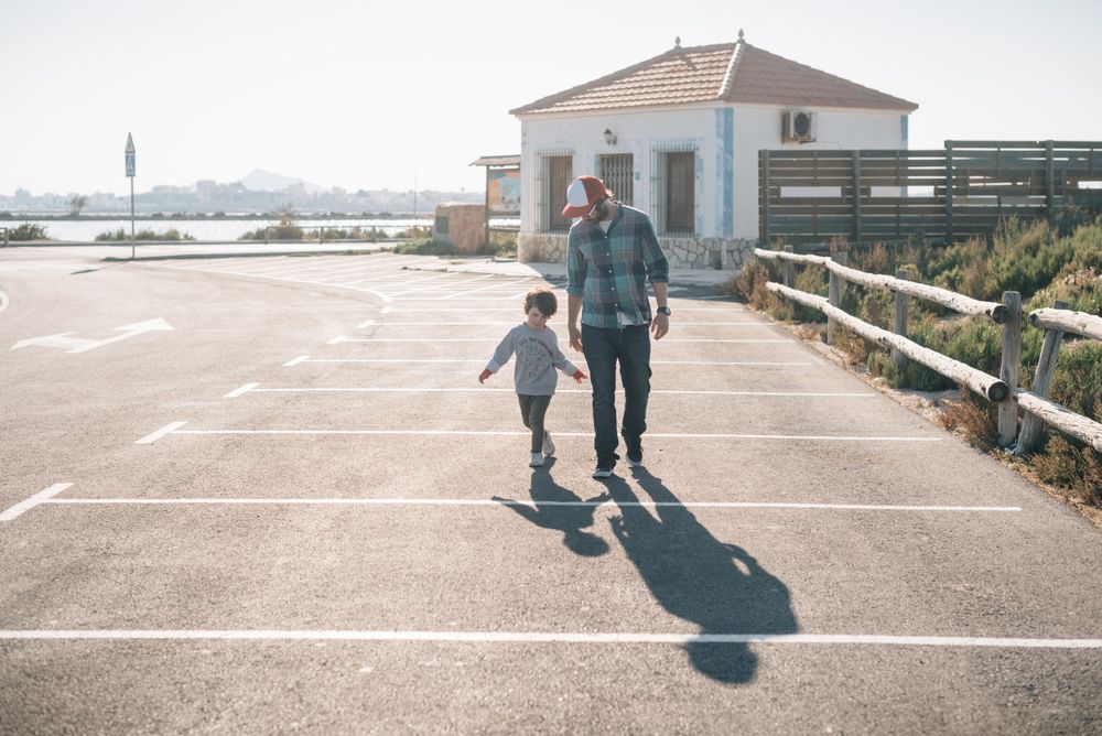 Man with boy walking on street