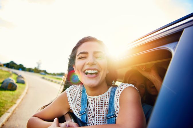Laughing woman half outside of car window