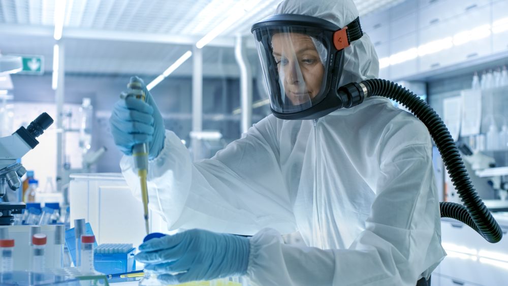 Medical Virology Research Scientist Works in a Hazmat Suit with Mask