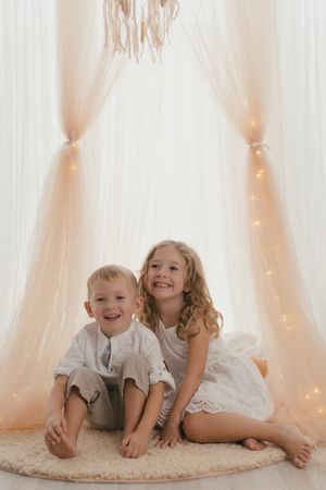 Sister embracing little brother at home