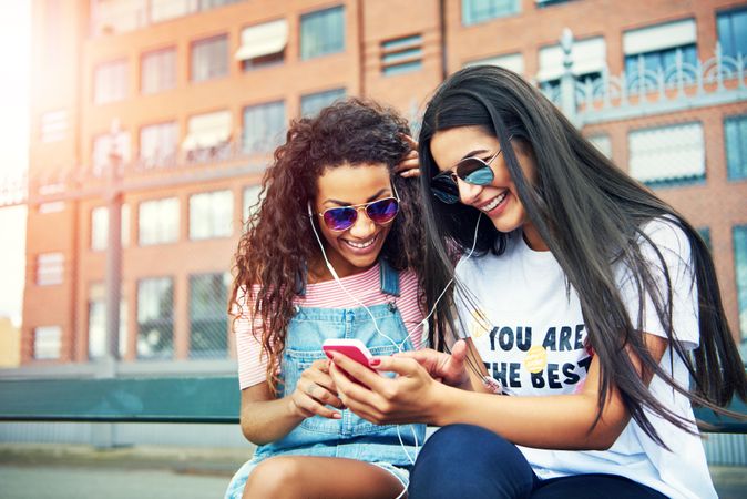 Cheerful friends watching something funny on smart phone together