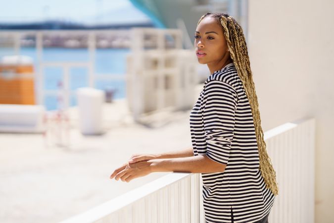Female leaning on railing of the pier looking around